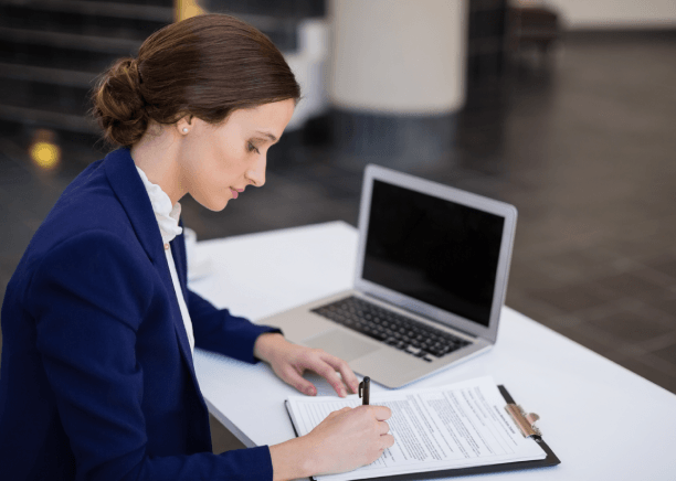 A translator reviews a birth certificate for document accuracy using Translation Services in Boston at a desk.
