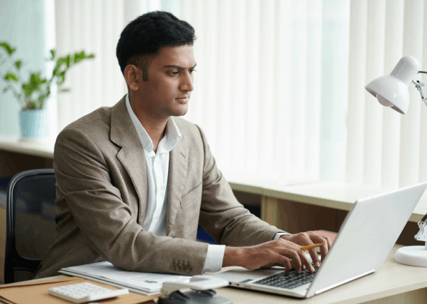 Translator marks up a property contract on a laptop, using Translation Services in Newton for real estate compliance.