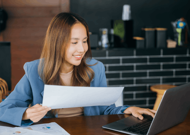 A translator compares Vietnamese and English pages, delivering Vietnamese Translation Services in Massachusetts for clear.